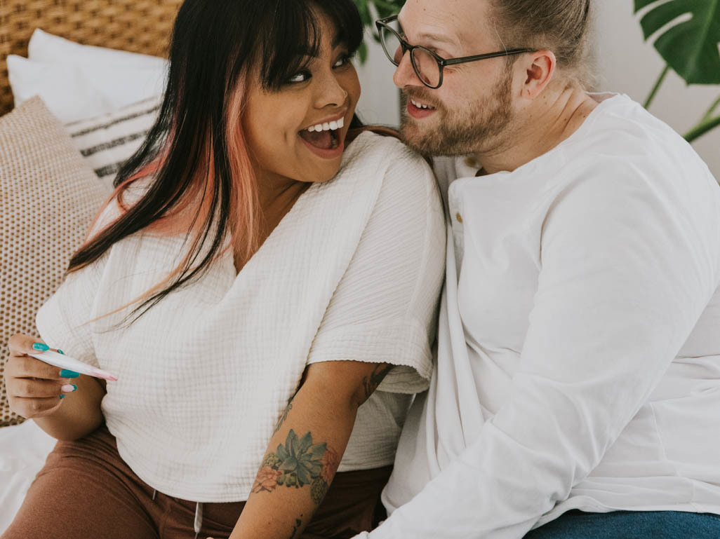 happy couple looking at a pregnancy test