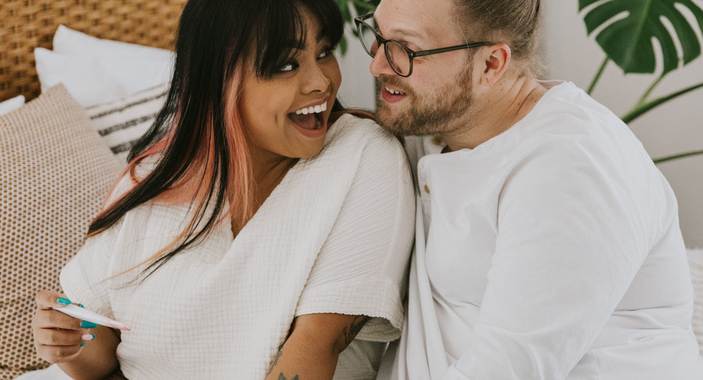 happy couple looking at a pregnancy test