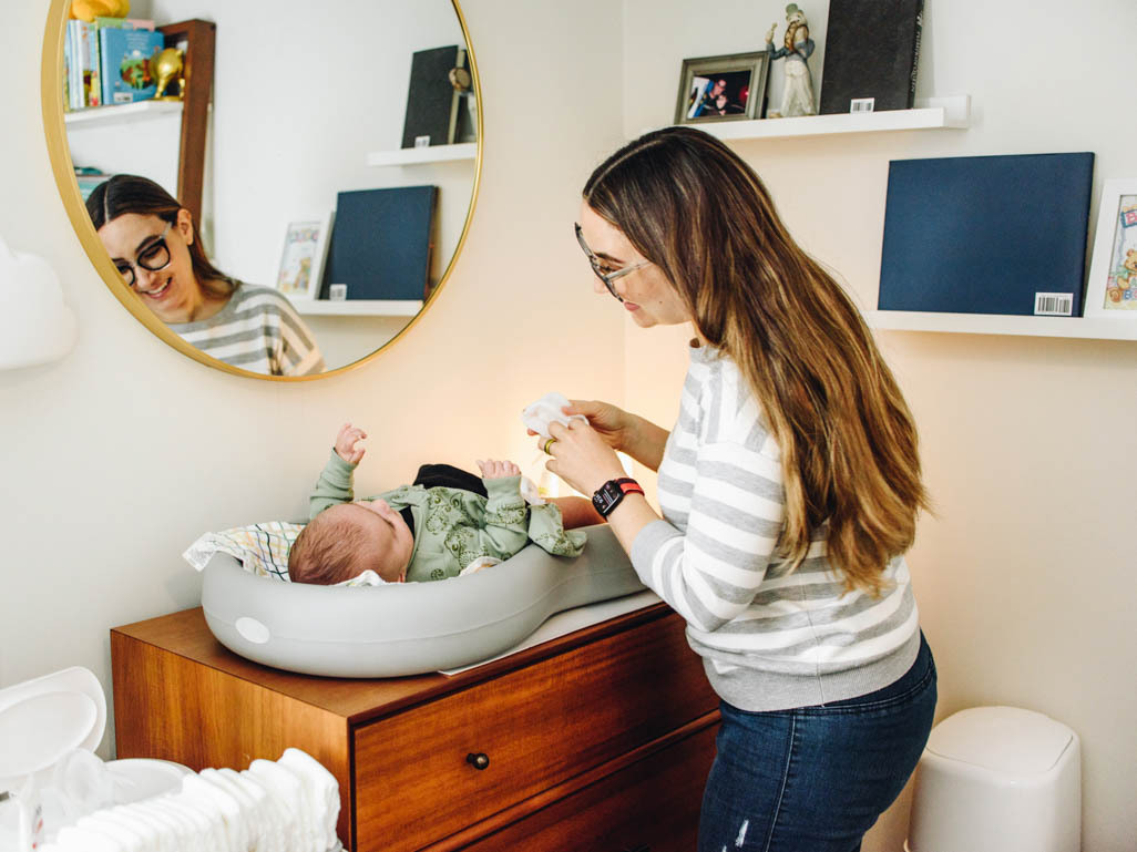 A mom changing her baby's diaper at a changing table