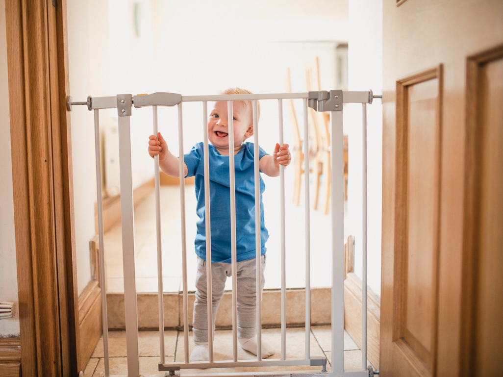 young child peeking through baby gate