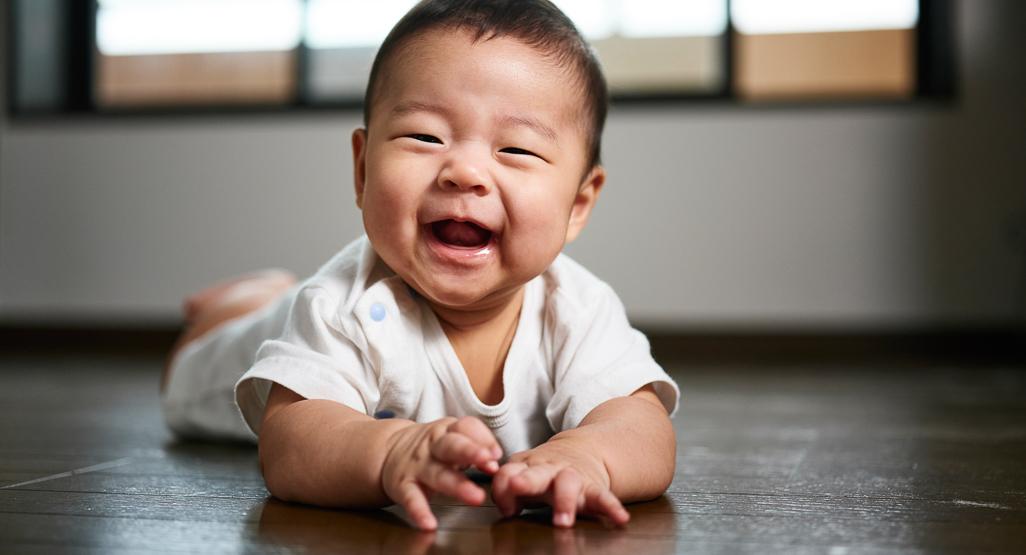 smiling baby lying on his tummy