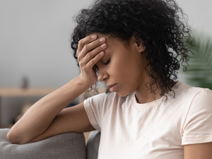 A woman holding her hand to her forehead