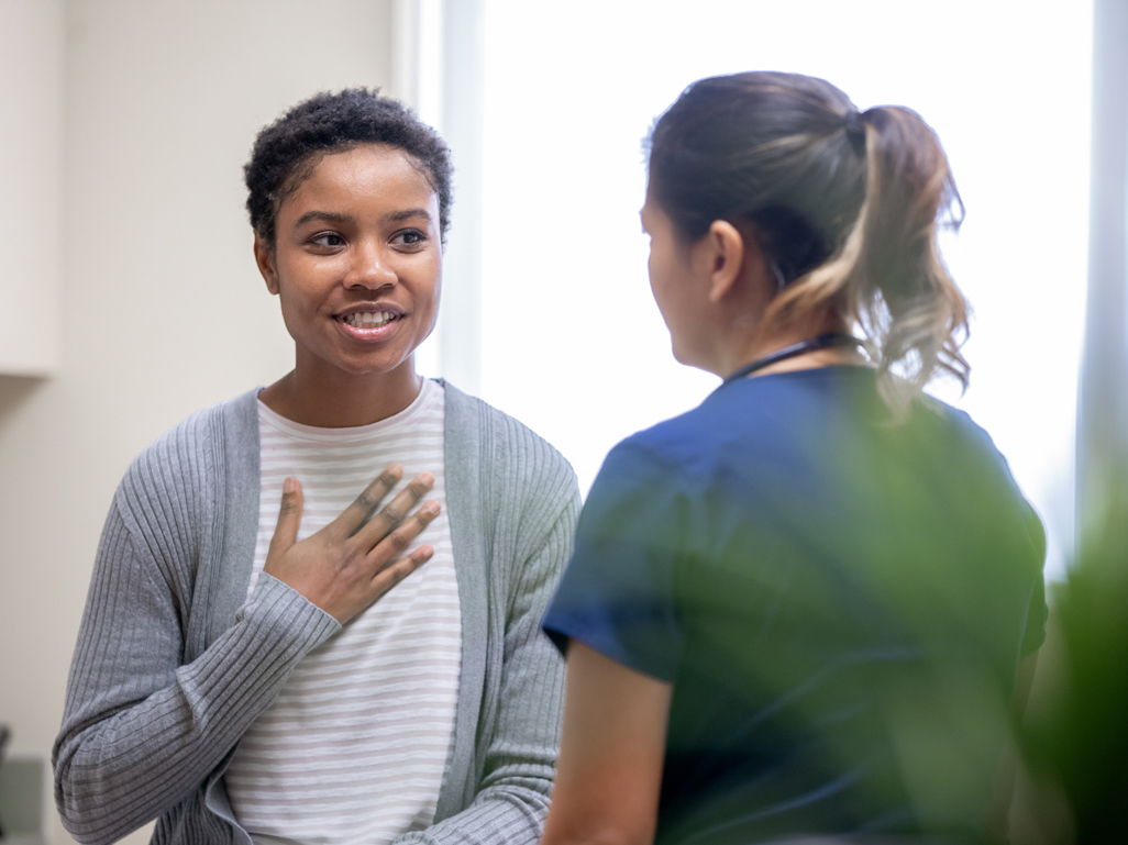 young woman speaking with medical professional