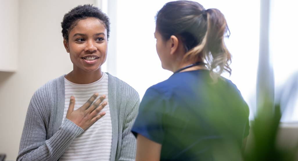 young woman speaking with medical professional