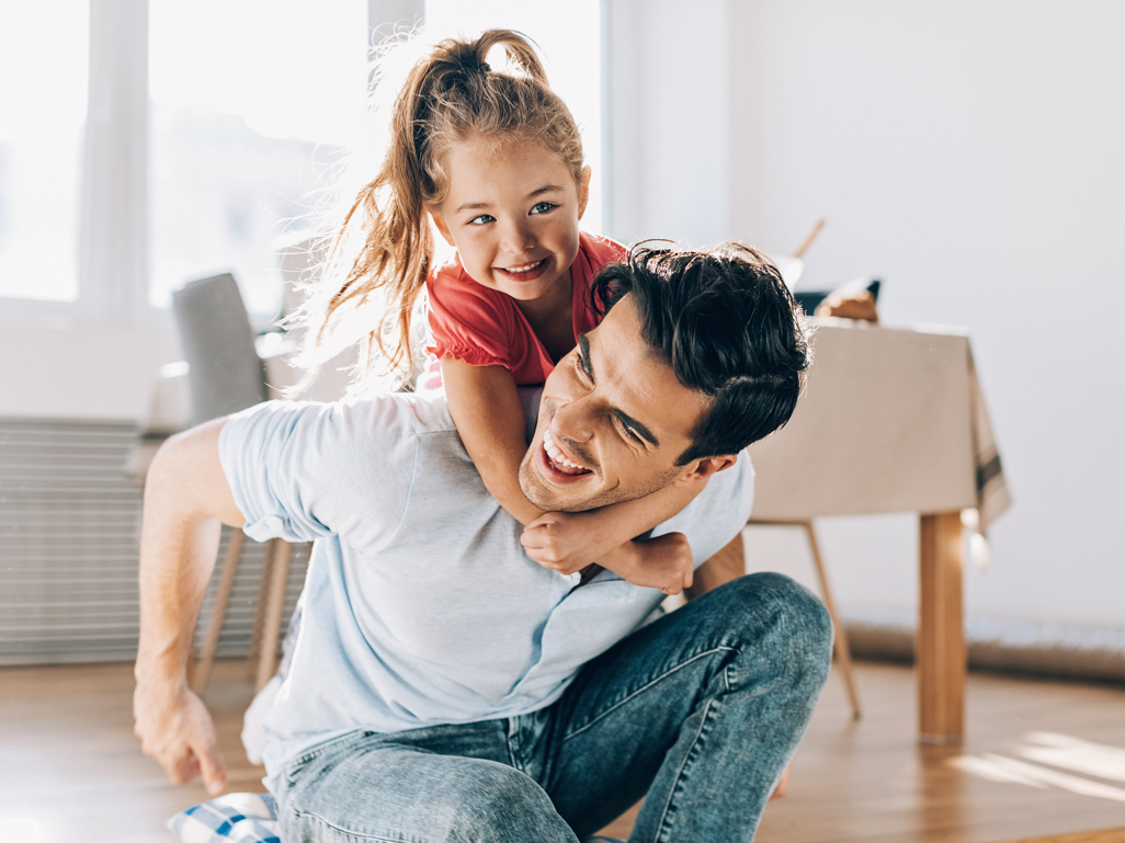 little girl climbing on dads back