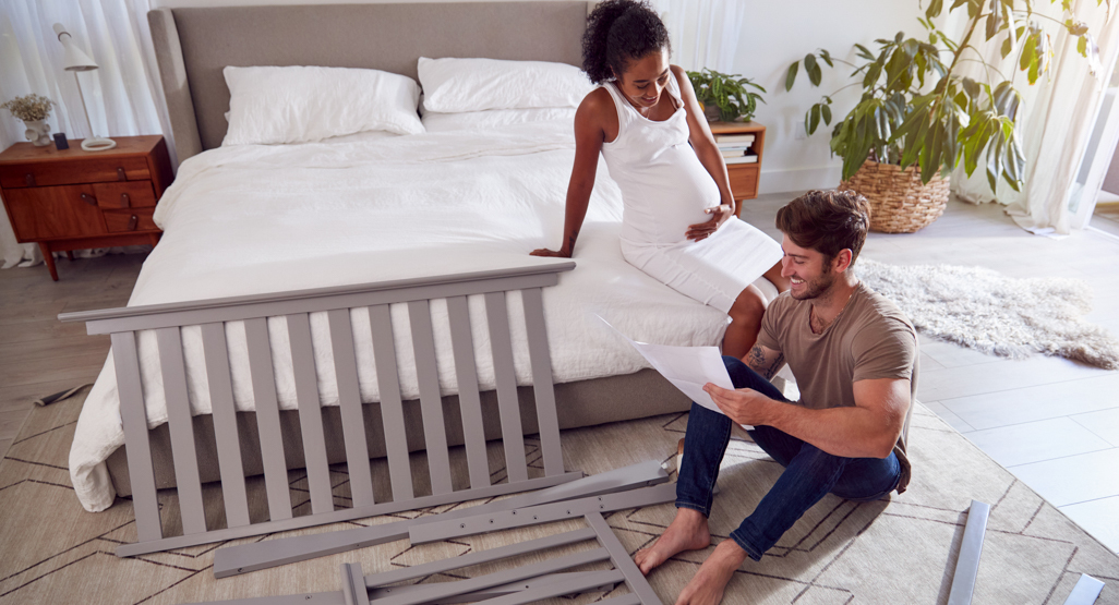 man and pregnant woman setting up nursery