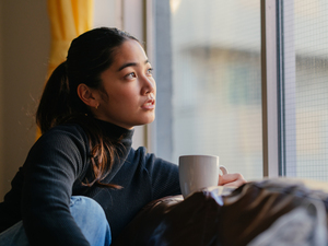 thoughtful young woman looking out the window