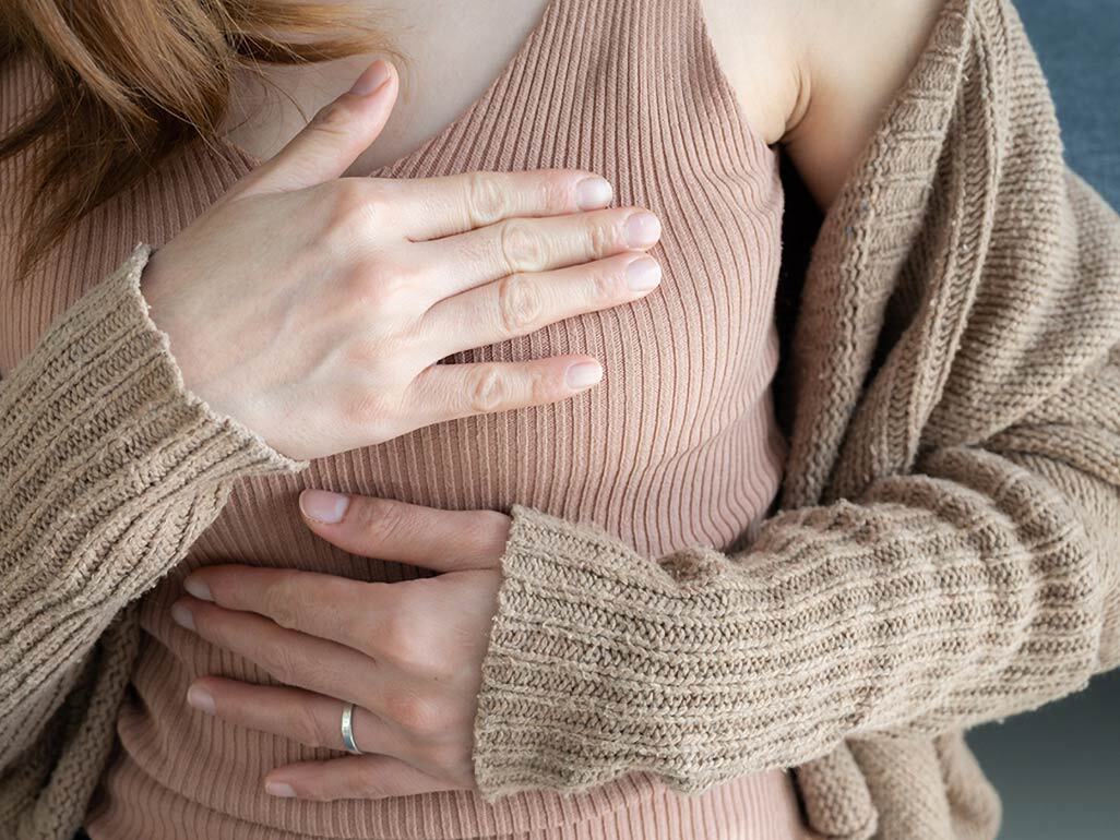 woman with her hand over her breast