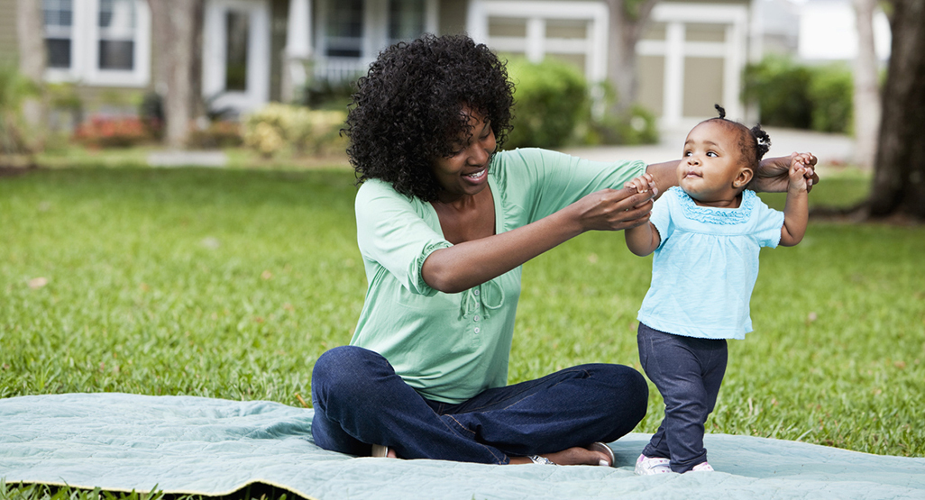 mom helping baby stand