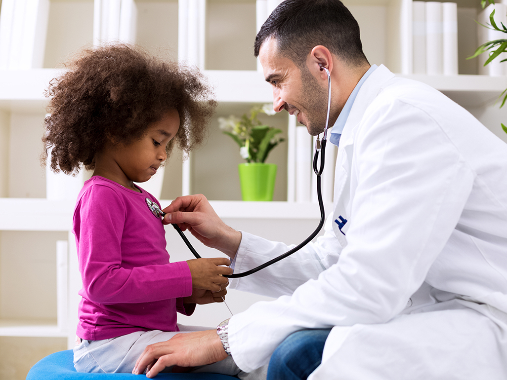 doctor using stethoscope on little girl