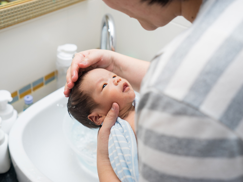 baby boy getting his hair washed in a sink