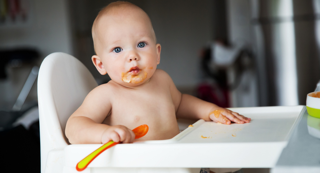 baby learning to eat with a spoon