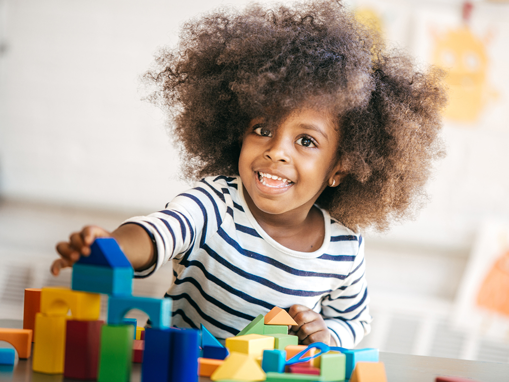 smiling girl playing with building blocks