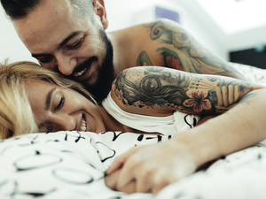 Two people cuddling in bed