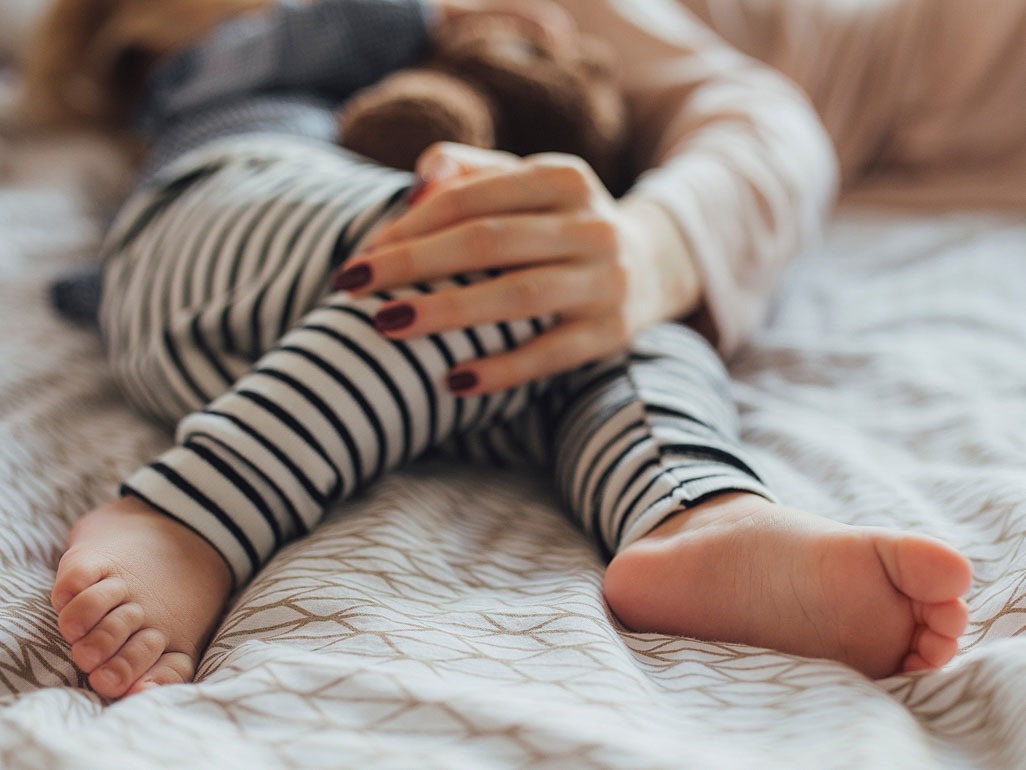 mom's hand holding toddler's knee