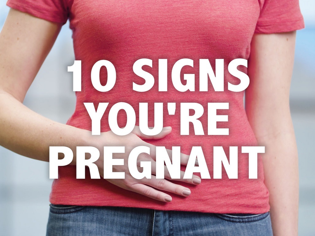 woman in t-shirt and jeans, with text saying: 10 signs you are pregnant